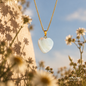 Natural Turkish Shell pendant necklace with a gold-plated chain displayed among delicate flowers