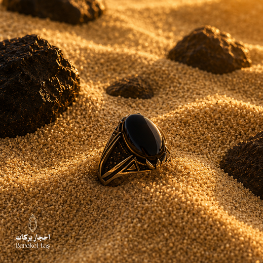 Luxury men’s Black Onyx ring in 925 Sterling Silver displayed on natural sand.