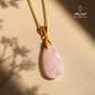 Natural pink Quartz pendant necklace with a gold-plated chain on a warm beige background