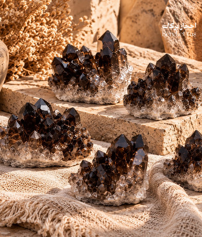 Natural raw Smoky Quartz crystal clusters with dark brown crystal formations displayed on a warm beige surface