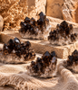 Natural raw Smoky Quartz crystal clusters with dark brown crystal formations displayed on a warm beige surface