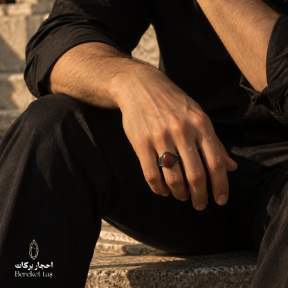 Man wearing a natural Red Agate ring in 925 Sterling Silver with a black outfit, showcasing the red gemstone and detailed silver setting.