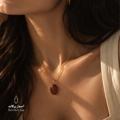 Close-up of a natural red Agate pendant necklace with a gold-plated chain worn elegantly