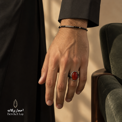 Man wearing a natural Red Agate ring in 925 Sterling Silver with black traditional attire, highlighting the red gemstone and ornate silver setting.