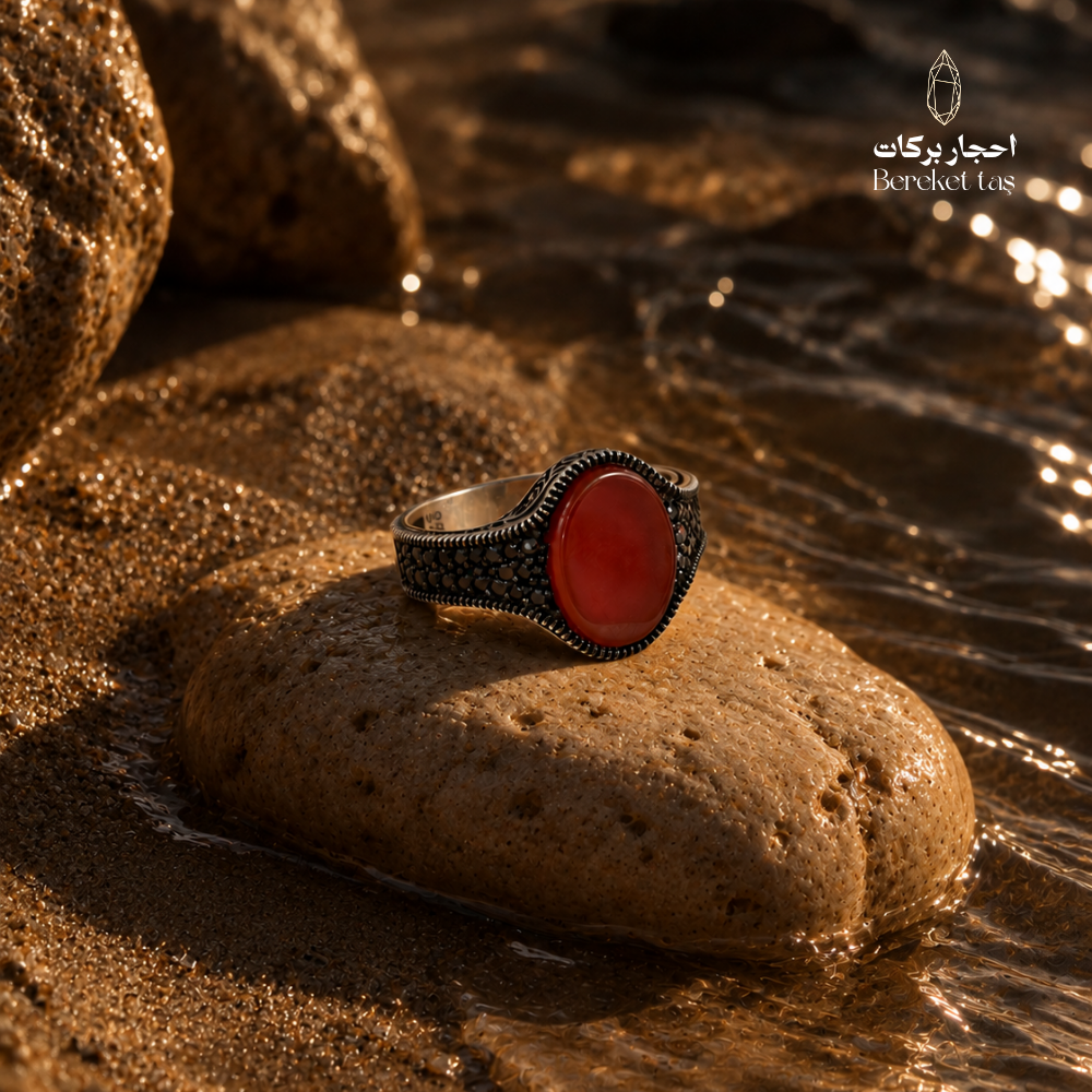 Natural Red Agate ring in 925 Sterling Silver displayed on a stone surrounded by water, highlighting the deep red gemstone and ornate silver setting.