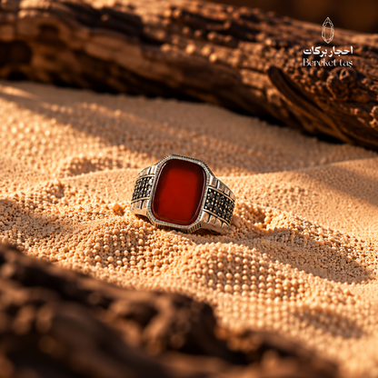 Natural Red Agate men's ring in 925 Sterling Silver displayed on warm sand, showcasing the deep red gemstone and geometric silver detailing.