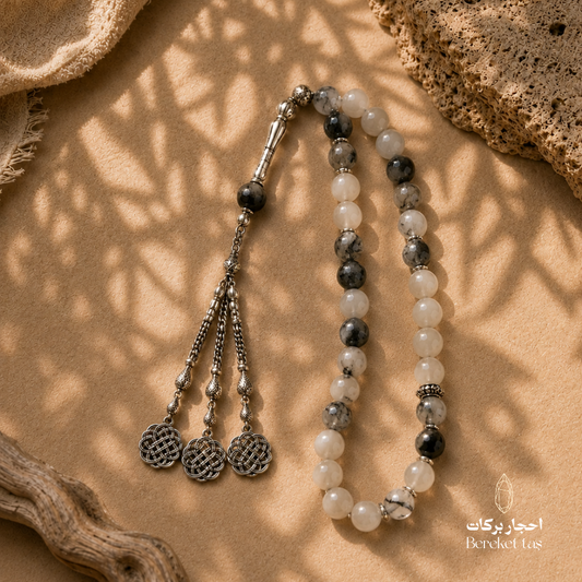 Natural rutilated quartz prayer beads with black and white stone patterns